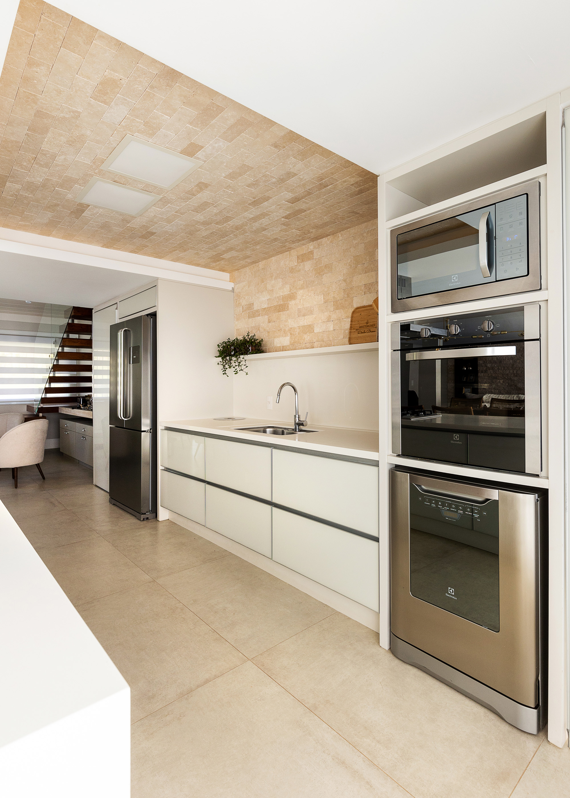 Ambiente claro com pé-direito em travertino e luz natural — atmosfera do estúdio